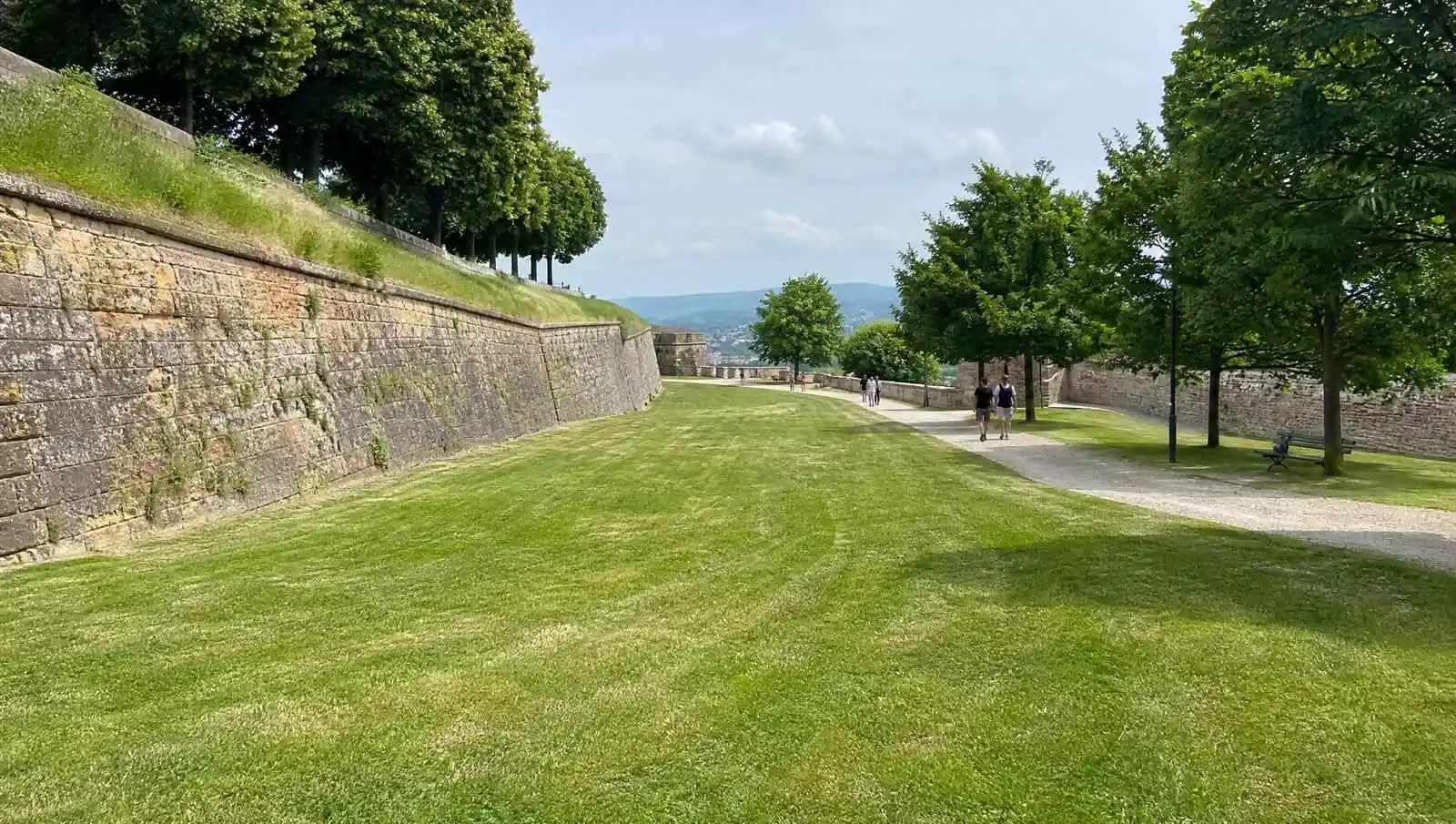Wide mown grass and old walls on a fortress hilltop